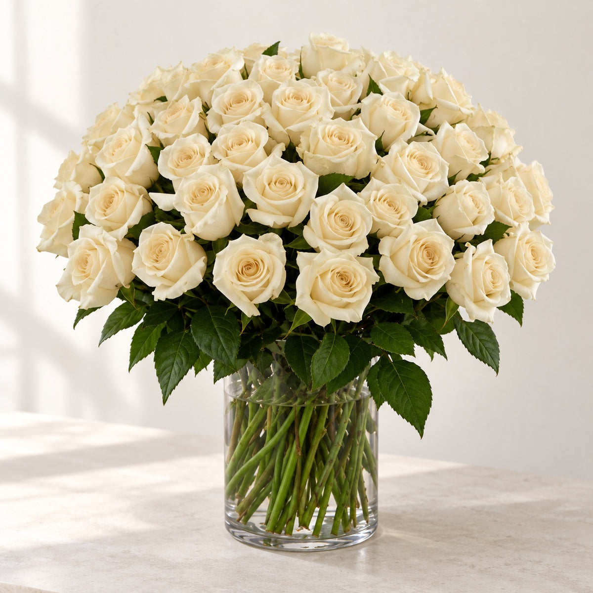 AI-assisted photo-style preview of 'Crem-de-la-Crem' Medium Stem Vase Arrangement, 50-rose option; actual arrangement and proportions vary.