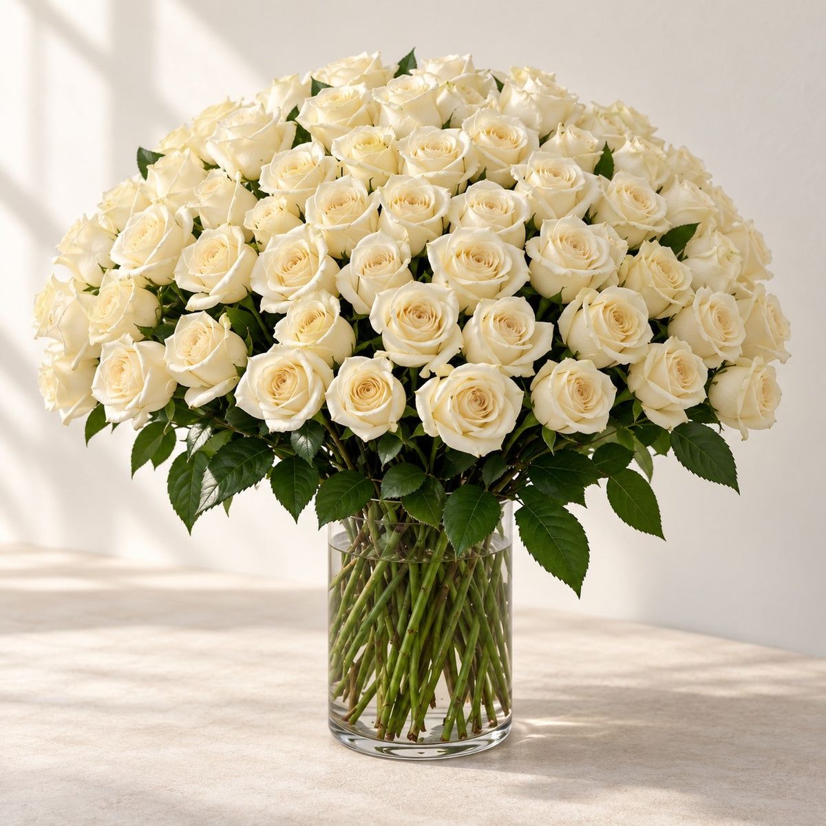 AI-assisted photo-style preview of 'Crem-de-la-Crem' Medium Stem Vase Arrangement, 75-rose option; actual arrangement and proportions vary.