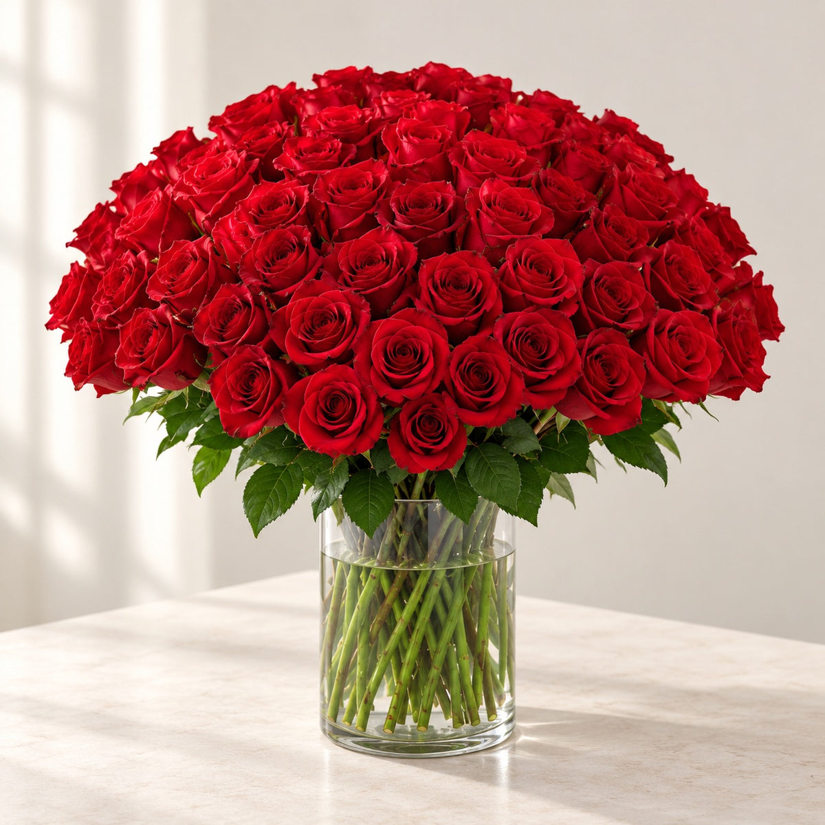 AI-assisted photo-style preview of 'Explorer' Medium Stem Vase Arrangement, 100-rose option; actual arrangement and proportions vary.