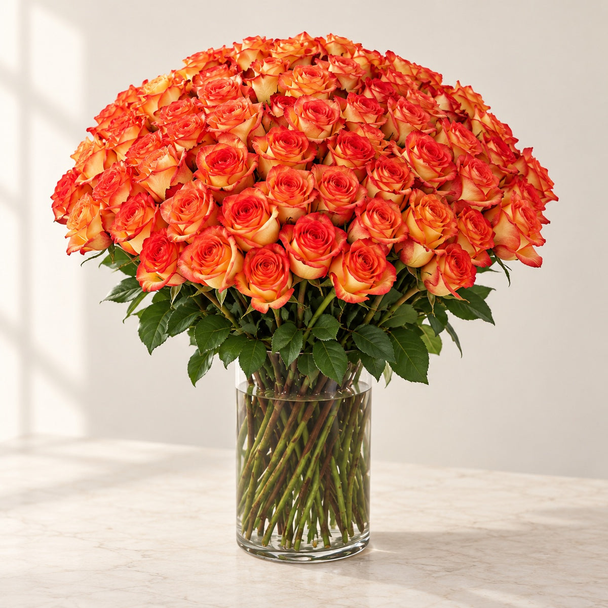 AI-assisted photo-style preview of 'High & Orange' Long Stem Vase Arrangement, 100-rose option; actual arrangement and proportions vary.