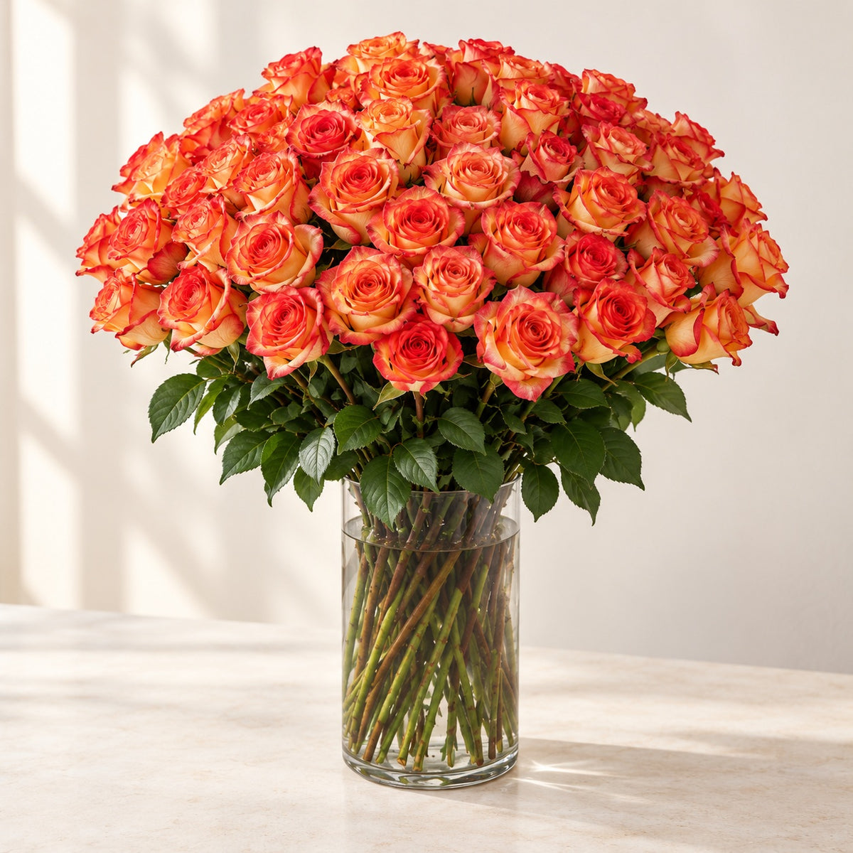 AI-assisted photo-style preview of 'High & Orange' Long Stem Vase Arrangement, 75-rose option; actual arrangement and proportions vary.
