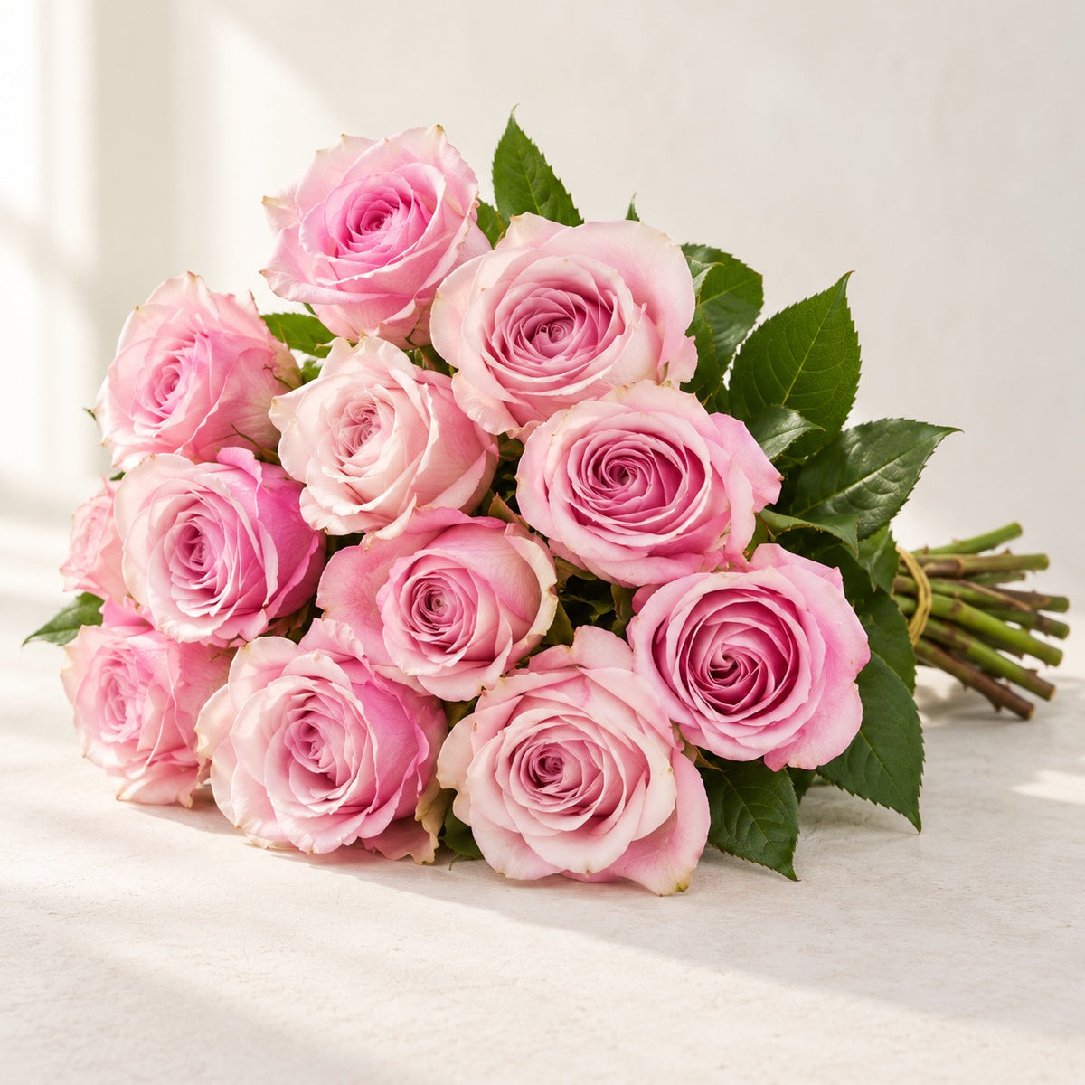 AI-assisted photo-style preview of 'Secret Garden' Light Pink bi-Color Roses, 12-rose option; actual arrangement and proportions vary.